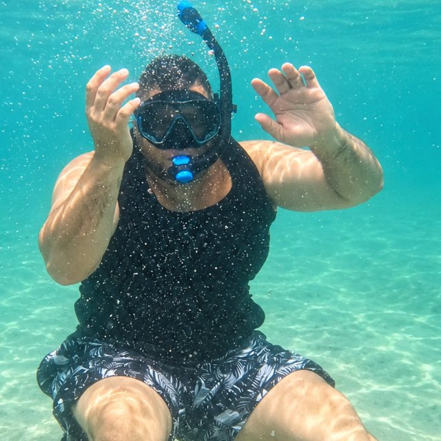Ty snorkeling underwater in clear turquoise water.